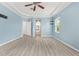 Main bedroom featuring wood-look floors, tray ceiling, light blue walls, and ensuite bathroom entrance at 2347 123Rd E Pl, Parrish, FL 34219