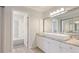 Bright bathroom featuring dual sinks, large mirror, and shower over tub combo with decorative tiles at 2383 Lakeside Mews # D3, Sarasota, FL 34235