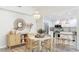 Dining area with a chandelier, a large round mirror, and a view to the kitchen at 2383 Lakeside Mews # D3, Sarasota, FL 34235