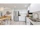 Bright kitchen features white cabinets, subway tile backsplash, stainless steel appliances, and stone countertops at 2383 Lakeside Mews # D3, Sarasota, FL 34235