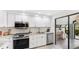 Modern kitchen with white cabinets, stainless steel appliances, and a view of a home office at 2383 Lakeside Mews # D3, Sarasota, FL 34235