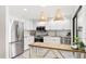 Bright kitchen featuring white cabinets, stainless steel appliances, and a breakfast bar at 2383 Lakeside Mews # D3, Sarasota, FL 34235