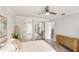 Bright main bedroom with light walls, ceiling fan, dresser, and view to attached bathroom at 2383 Lakeside Mews # D3, Sarasota, FL 34235