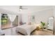 Bright main bedroom with ceiling fan, light walls, and sliding glass doors to lanai at 2383 Lakeside Mews # D3, Sarasota, FL 34235