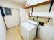 The laundry room includes a dryer and shelving for storage at 2607 29Th W Ave, Bradenton, FL 34205