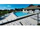 Community pool with ample lounge chairs and a building with pool rules on a sunny day at 2607 29Th W Ave, Bradenton, FL 34205