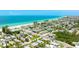 Aerial view of turquoise home near a pristine sandy beach and clear blue ocean at 2713 Avenue C, Holmes Beach, FL 34217