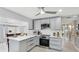 Well-lit kitchen showcasing gray cabinetry, stainless steel appliances, and white countertops at 2713 Avenue C, Holmes Beach, FL 34217