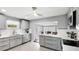 Well-lit kitchen showcasing gray cabinetry, stainless steel appliances, and white subway tile backsplash at 2713 Avenue C, Holmes Beach, FL 34217