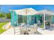 Inviting outdoor patio with table, umbrella, chairs, and barbecue grill at 2713 Avenue C, Holmes Beach, FL 34217