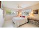 Bright bedroom featuring a queen-sized bed, two windows with blinds, and overhead ceiling fan at 2807 Coral Way, Punta Gorda, FL 33950