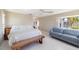 Bright bedroom with a ceiling fan, bench, and a blue-striped sofa at 2807 Coral Way, Punta Gorda, FL 33950