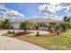 Charming single-story home with a tile roof, well-manicured lawn and circular driveway surrounded by tropical landscaping at 2807 Coral Way, Punta Gorda, FL 33950