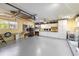 Spacious two-car garage with white cabinetry, sink, ceiling fan, and overhead storage at 2807 Coral Way, Punta Gorda, FL 33950