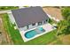 Aerial view of a home showcasing a modern pool, patio area, and lush green landscaping, perfect for outdoor living at 289 Long Meadow Ln, Rotonda West, FL 33947