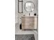 Contemporary bathroom featuring a wood vanity, round mirror and modern fixtures at 289 Long Meadow Ln, Rotonda West, FL 33947