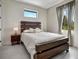 Well-lit bedroom with a wooden headboard, plush bedding, and window views for a serene atmosphere at 289 Long Meadow Ln, Rotonda West, FL 33947