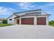 Striking house featuring a modern design with a white exterior and wood-paneled garage doors at 289 Long Meadow Ln, Rotonda West, FL 33947