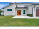 Modern home showcasing a clean white facade and a stylish wood double-door entrance at 289 Long Meadow Ln, Rotonda West, FL 33947