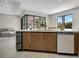 Kitchen island with sink, beverage cooler, dishwasher, wood cabinetry, and access to the living area at 289 Long Meadow Ln, Rotonda West, FL 33947