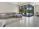 Open-concept living room with a gray sectional and large sliding doors leading to the outdoor area at 289 Long Meadow Ln, Rotonda West, FL 33947