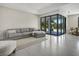 Bright living room with gray sofa, ottoman, and sliding glass doors opening to a patio at 289 Long Meadow Ln, Rotonda West, FL 33947