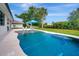 Beautiful backyard with a sparkling pool, featuring a lounge area and lush landscaping at 289 Long Meadow Ln, Rotonda West, FL 33947