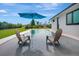 Relaxing backyard pool area with seating and umbrella, surrounded by lush green landscaping at 289 Long Meadow Ln, Rotonda West, FL 33947
