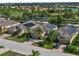 Residential neighborhood with homes equipped with solar panels, mature trees, and nearby lake and golf course at 305 Siena Vista Pl, Sun City Center, FL 33573