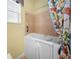 Bathtub with a printed curtain and a window, in a bathroom with beige tiling at 305 Siena Vista Pl, Sun City Center, FL 33573