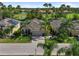 Beautifully landscaped home boasts lush greenery, swaying palms, and a serene lake view, offering a tranquil Florida lifestyle at 305 Siena Vista Pl, Sun City Center, FL 33573