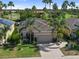 Well-maintained home features a two-car garage, lush landscaping, and a welcoming entrance at 305 Siena Vista Pl, Sun City Center, FL 33573