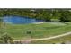 Scenic golf course view with lush greenery, a tranquil lake, and golfers enjoying a sunny day on the green at 305 Siena Vista Pl, Sun City Center, FL 33573