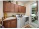 Laundry room with sink, washer, dryer, ample cabinetry and a view of a white car in the garage at 305 Siena Vista Pl, Sun City Center, FL 33573
