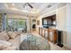 Inviting living room features a modern entertainment center and sliding glass doors leading to the lanai and pool at 305 Siena Vista Pl, Sun City Center, FL 33573