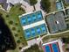 Aerial view featuring pickleball and tennis courts near a pond, surrounded by trees, offering various recreational opportunities at 305 Siena Vista Pl, Sun City Center, FL 33573