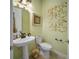 Powder room featuring a pedestal sink, a toilet, and decorative wall art at 305 Siena Vista Pl, Sun City Center, FL 33573