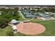 Aerial view of the baseball field and multiple tennis courts in a well-maintained sports complex surrounded by trees at 305 Siena Vista Pl, Sun City Center, FL 33573