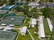 Aerial view of community tennis courts with lush landscaping and nearby clubhouse parking at 305 Siena Vista Pl, Sun City Center, FL 33573