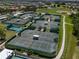 Aerial view of multiple well-maintained tennis courts surrounded by lush landscaping in a vibrant community at 305 Siena Vista Pl, Sun City Center, FL 33573