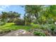 Beautifully landscaped backyard with palm trees, shrubs and a concrete patio at 4198 Vallarta Ct # 3027, Sarasota, FL 34233