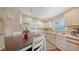 Well-lit kitchen featuring white cabinets, modern appliances, and an adjacent dining area at 4198 Vallarta Ct # 3027, Sarasota, FL 34233