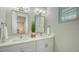 Bright bathroom with a double sink vanity, stylish mirrors, and a window with blinds at 4322 Marina View Way, Cortez, FL 34215