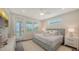 Bright bedroom with a ceiling fan, a gray upholstered bed, and access to an outdoor deck at 4322 Marina View Way, Cortez, FL 34215