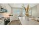 Modern kitchen with stainless steel appliances, a bright window, and white cabinets with tile backsplash at 4322 Marina View Way, Cortez, FL 34215