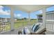 Inviting covered porch features a lounge chair and view of green space and blue sky at 4322 Marina View Way, Cortez, FL 34215