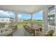 Screened porch featuring outdoor dining with comfortable seating and views of green space at 4322 Marina View Way, Cortez, FL 34215