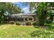 Green backyard featuring a screened-in pool and brick patio with carefully manicured landscaping around the perimeter at 4353 Indian Point Trl, Sarasota, FL 34238