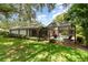 Green backyard featuring a screened-in pool and brick patio, creating an ideal spot for entertaining guests at 4353 Indian Point Trl, Sarasota, FL 34238
