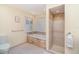 A bright bathroom offers a tub and separate glass enclosed shower with stone accents at 4353 Indian Point Trl, Sarasota, FL 34238